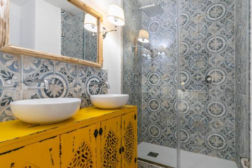 a bathroom with two white bowls on a yellow dresser at H-A Aparthotel Hotel Quo in Madrid