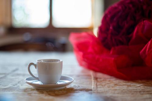 a coffee cup on a table with a red chair at Podere Cerciano in Radicondoli