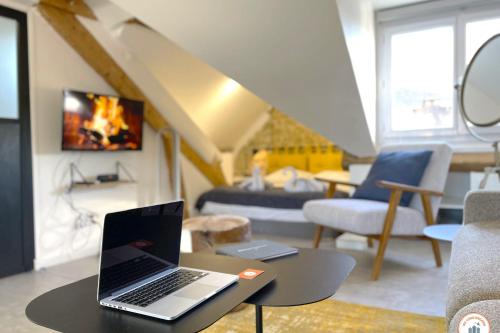 - un ordinateur portable installé sur une table dans le salon dans l'établissement Loft - Echappée Mer - Casino 50m, à Trouville-sur-Mer