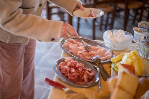 a woman is serving food on a buffet table at Podere Cerciano in Radicondoli