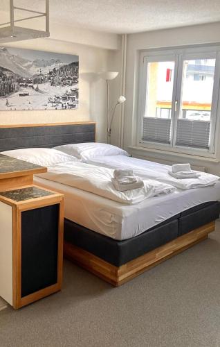 a large bed in a bedroom with a window at Studio Arosa von Swisspartments in Arosa