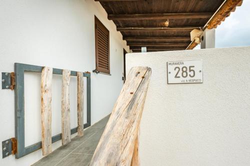 a sign on the side of a building with a door at Villetta Anastasia in Costa Rei