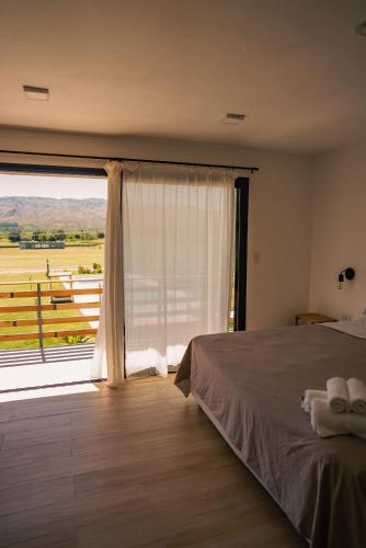 a bedroom with a bed and a large window at Casa Luoni Hotel Boutique & Aparts in San Luis