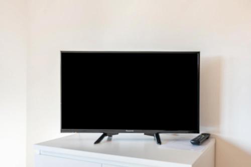 a flat screen tv sitting on top of a white cabinet at Pension am Hohberghof Dielheim in Dielheim
