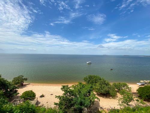 a view of a beach with a boat in the water at CASA NA PRAIA - 5 QUARTOS - PISCINA - CHURASQUEIRA e VISTA EXTRAORDINARIA - 20 PESSOAS in Santarém