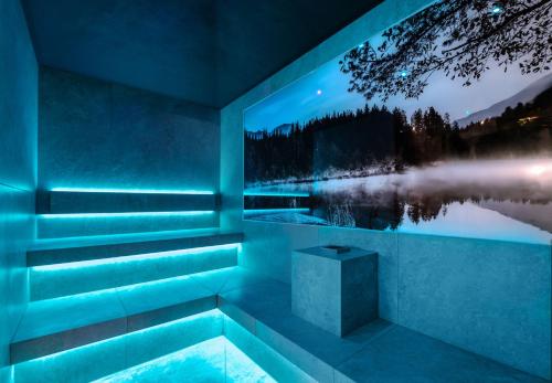 a jacuzzi tub with a view of a lake at night at Wellness & Naturhotel Tonihof in Langdorf im Landkreis Regen