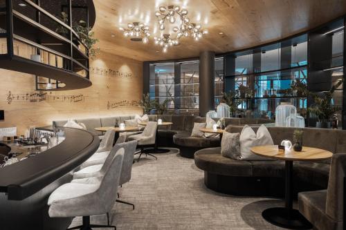 a restaurant with couches and tables and a chandelier at Wellness & Naturhotel Tonihof in Langdorf im Landkreis Regen