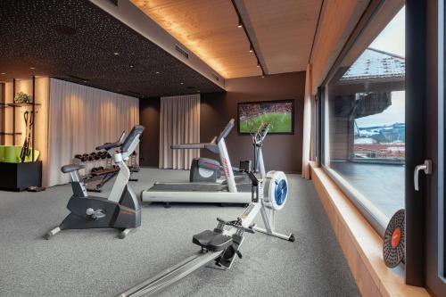 a fitness room with cardio equipment and a window at Wellness & Naturhotel Tonihof in Langdorf im Landkreis Regen