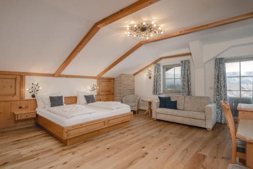 a bedroom with a bed and a couch and a table at Wellness & Naturhotel Tonihof in Langdorf im Landkreis Regen