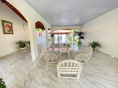 a group of chairs and tables in a room at CASA NA PRAIA - 5 QUARTOS - PISCINA - CHURASQUEIRA e VISTA EXTRAORDINARIA - 20 PESSOAS in Santarém