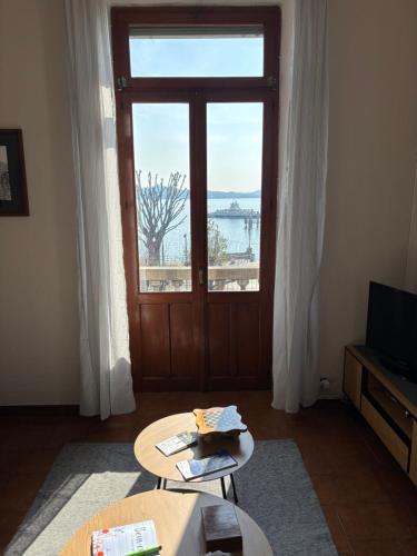 a living room with a large window and a door at Casa Caterina in Intra