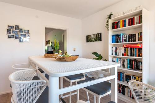 a white table and chairs in a room with bookshelves at Pension am Hohberghof Dielheim in Dielheim