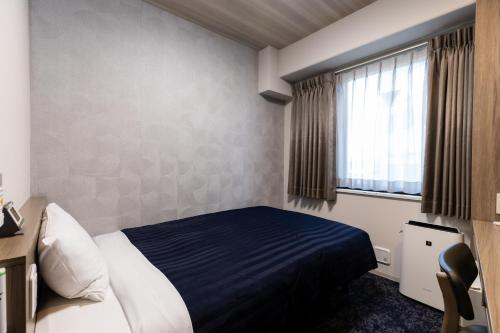 a hotel room with a bed and a window at Kyoto Plaza Hotel in Kyoto