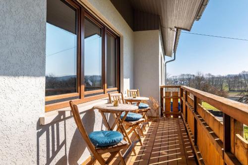 a balcony with two tables and chairs and windows at Pension am Hohberghof Dielheim in Dielheim