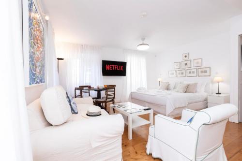 a white living room with white furniture and a bed at Ventoura Suites, Corfu Old Town in Corfu