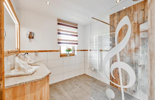 a bathroom with two sinks and a shower at Wellness & Naturhotel Tonihof in Langdorf im Landkreis Regen