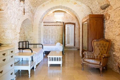 1 dormitorio con 2 camas y 1 silla en una habitación en Agriturismo Masseria Carrone, en Carovigno