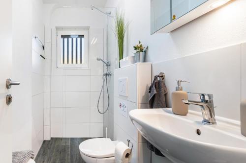 a white bathroom with a sink and a toilet at Pension am Hohberghof Dielheim in Dielheim