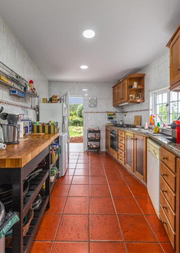 a large kitchen with a red tile floor at Casa Azul Belgica, Fiscal in Fiscal