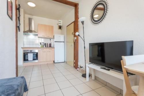 Il comprend une cuisine équipée d'un réfrigérateur et d'une télévision. dans l'établissement Bel appartement 4Pers Stationnement Gratuit Centre, à Mulhouse