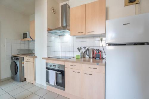 une cuisine avec des armoires en bois et un réfrigérateur dans l'établissement Bel appartement 4Pers Stationnement Gratuit Centre, à Mulhouse