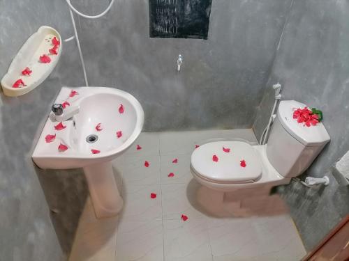 a bathroom with a toilet and a sink with hearts on the floor at The Golden Sand Villa in Unawatuna in Unawatuna