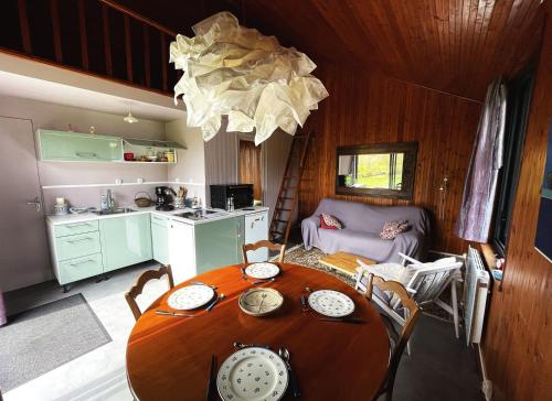 a kitchen and dining room with a table in a room at chalet in a quiet area, total disconnection in Ploubazlanec