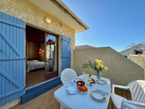 une table avec un bol de fruits sur une terrasse dans l'établissement Colibri - Studio à 500m des plages, à Mimizan-Plage