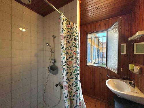une salle de bain avec un rideau de douche et un lavabo dans l'établissement Colibri - Studio à 500m des plages, à Mimizan-Plage