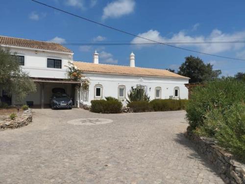 a white house with a car parked in front of it at Quinta Azul in Loulé