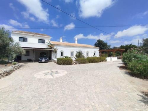 a large white house with a car parked in the driveway at Quinta Azul in Loulé