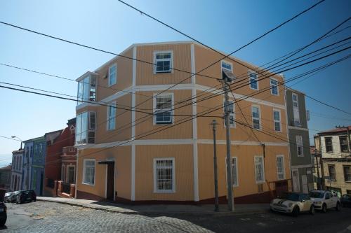 a large orange and white building on a street at Casa Galos Hotel & Lofts in Valparaíso