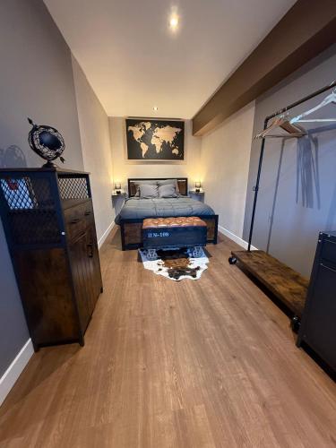 a bedroom with a bed and a wooden floor at L'escale en Othe avec jacuzzi in Estissac