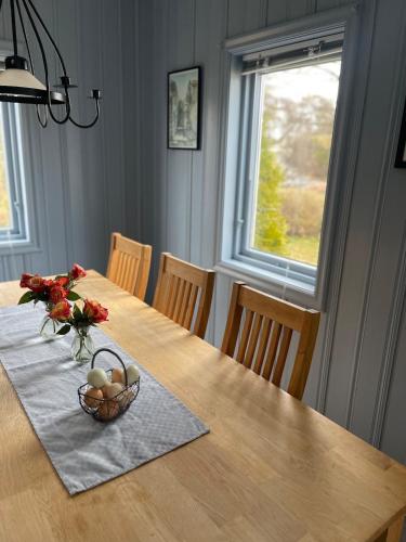 a dining room table with a basket of eggs and flowers at Beach cabin Eiketun in Larvik