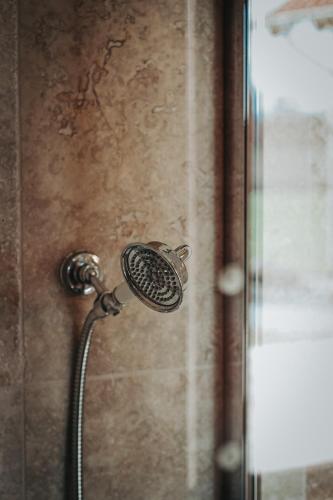 a shower with a shower head on a wall at Gościniec Gryszczeniówka & SPA in Wargowo