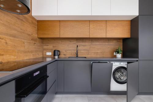 a kitchen with a sink and a washing machine at ApartView Plażowa Residence Szczyrk by Rent like home in Szczyrk
