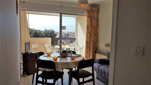 une table et des chaises dans une pièce avec une fenêtre dans l'établissement Proche port et plage T2 dans résidence avec ascenseur parking-4CA403, à Saint Cyprien Plage