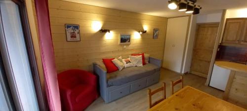 une petite pièce avec un canapé et une chaise rouge dans l'établissement T1 Les 2 Alpes Le Kandahar, à Les Deux Alpes