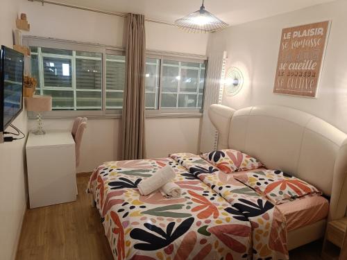 une chambre avec un lit avec une couette colorée dans l'établissement Chambre d'hôte confort - proximité directe Genève, à Annemasse