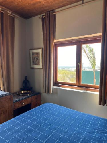 a bedroom with a blue bed and a window at The Ocean Breeze bungalow in Sidi Kaouki