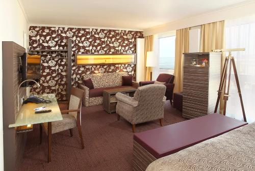 a hotel room with a living area with a bed and a couch at Strandhotel Duhnen in Cuxhaven