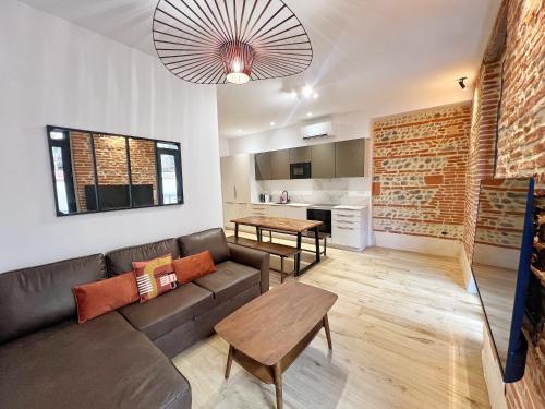 un salon avec un canapé et une table dans l'établissement Le Boutonnier - Centre - Luxe - Terrasse - Clim, à Toulouse