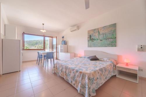 a bedroom with a bed and a table and chairs at Appartamenti Gli Orizzonti - Goelba in Marina di Campo