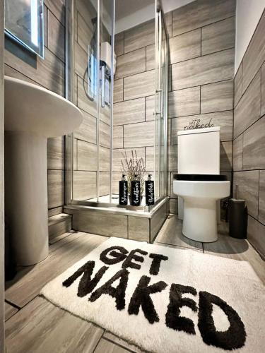 a bathroom with a toilet and a sign that says get married at Boutique Backyard Bungalow - Brimsdown in Enfield Lock