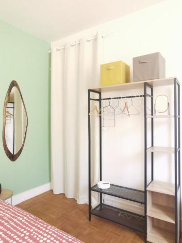 Cette chambre comprend une étagère avec un miroir et un lit. dans l'établissement Lovely and bright studio in Montmartre, à Paris