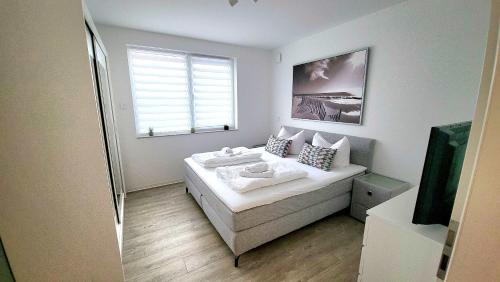 a small bedroom with a bed and a window at Fewo Exklusiv Hafenkante in Großräschen