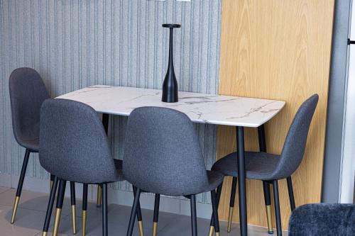 a table with four chairs and a vase on it at The Cloud 9 Penthouse by Blue Cloud Holidays in Sharjah Intl