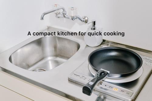 a pan sitting on a stove next to a sink at Shibuya Apartment Room Dogenzaka in Tokyo