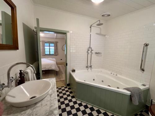 a bathroom with a large tub and a sink at Goat Square House - Historic Row Cottages in Tanunda