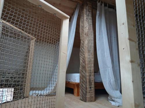 une chambre avec une cage et un lit dans une maison dans l'établissement gîte les 3 coquelicots bis, à Coublanc